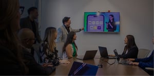 Equipo de personas en una sala de juntas mirando la pantalla que estas proyectando temas relacionados a UiX, Agencia de diseño UX/UI