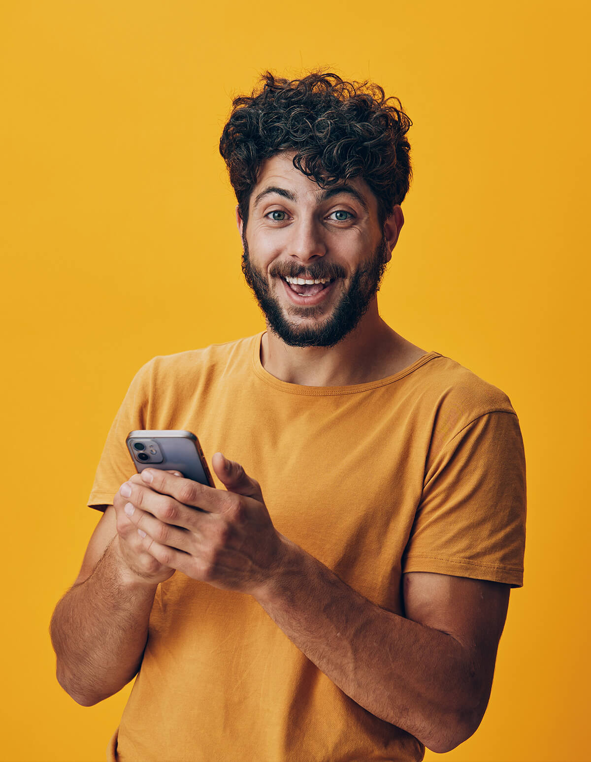 Persona usando un teléfono móvil en un entorno interior, vestida con un suéter rojo.